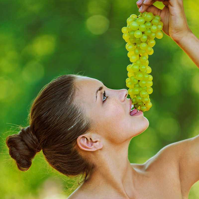 Красивая модель позирует с виноградом