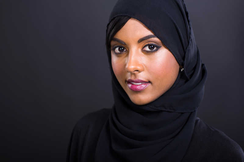 黑色背景下戴蓝色头巾的穆斯林美女