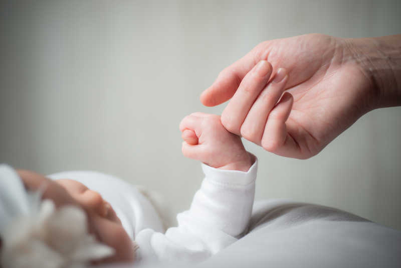 可爱的小婴儿握住妈妈的手