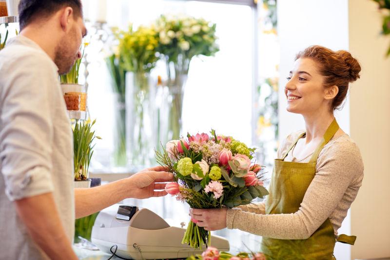 买花的男顾客看美女店员包装好的花束