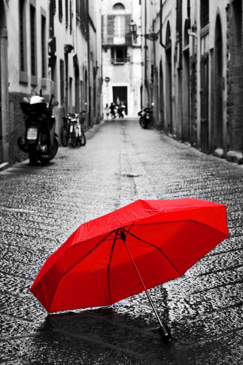 一个古老的意大利小镇的黑暗狭窄街道上的红色雨伞