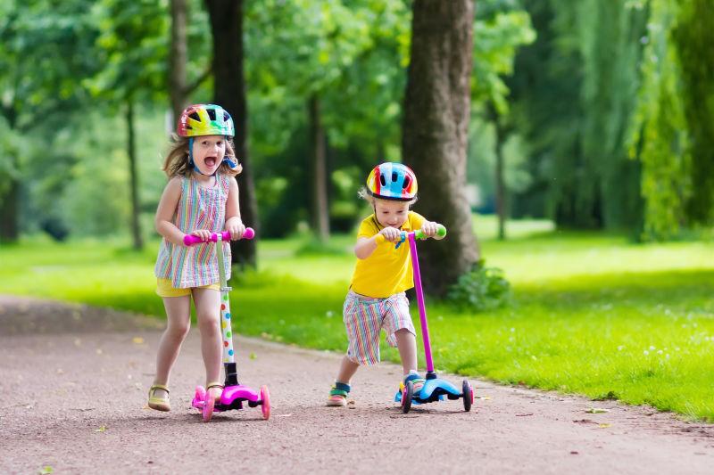 公园里骑自行车和踏板车的小孩