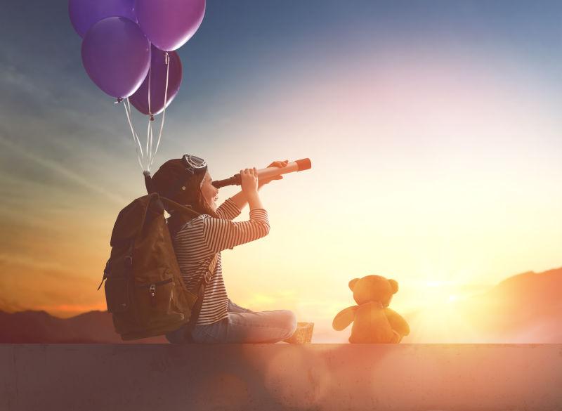 在日落的背景下孩子们乘气球飞行的梦想