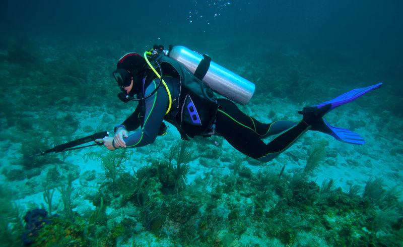 潜水员图片-海洋中的潜水员手拿氧气罐素材-高清图片