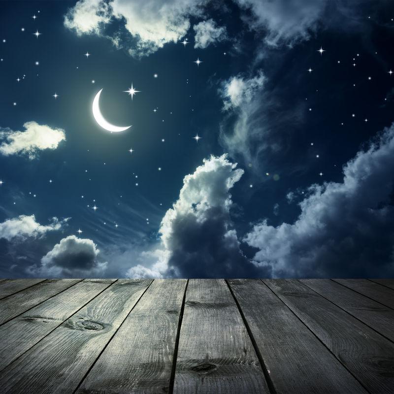 夜间星月夜空背景前的木桌