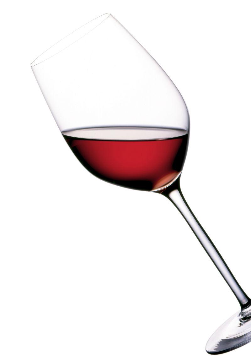 白色背景下倾斜的红葡萄酒杯