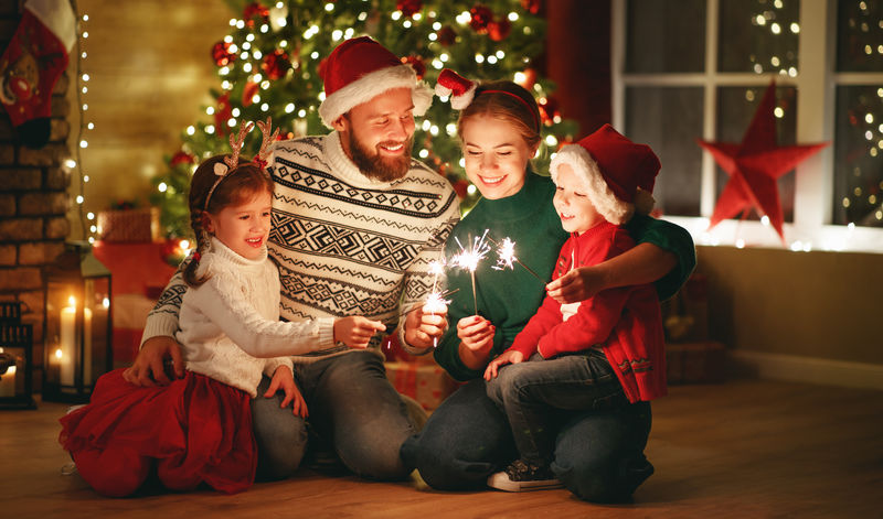 快乐的家庭母亲-父亲和孩子们庆祝圣诞节和新年-明亮的火花