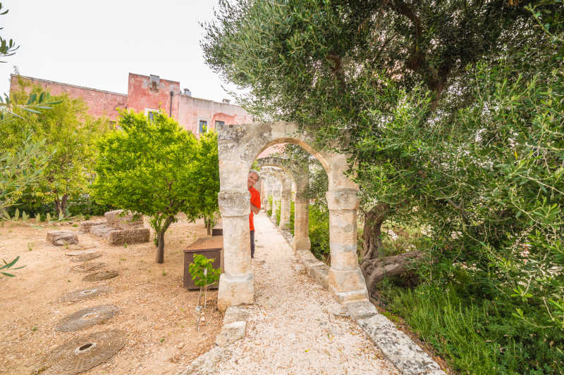 在花园拱门中拍照的老人