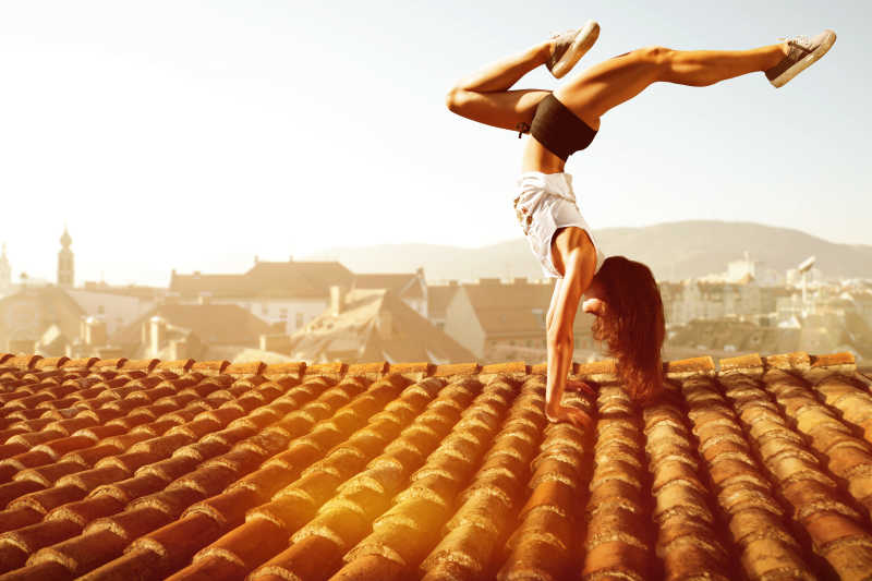 一个女人让屋顶上倒立