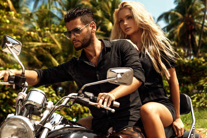 在路上和女友一起骑摩托车的男人