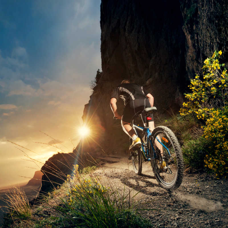 落日下骑着山地自行车兜风的人
