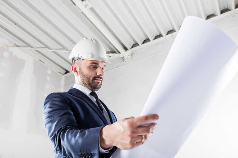 建筑师在工地上低头看图纸