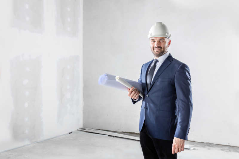 在工地上拿着设计图纸的人