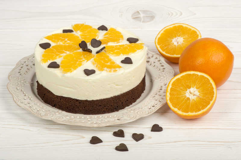 在白色的木制盘上的奶油橘子布朗尼蛋糕