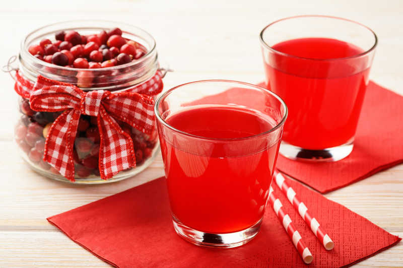 桌上的水果以及水果汁放在红色的餐纸上
