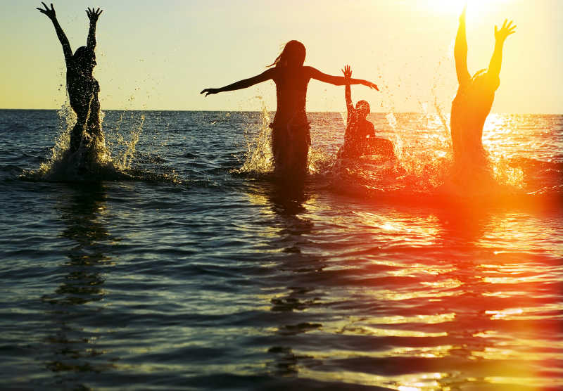 日落下的美女在海边戏耍