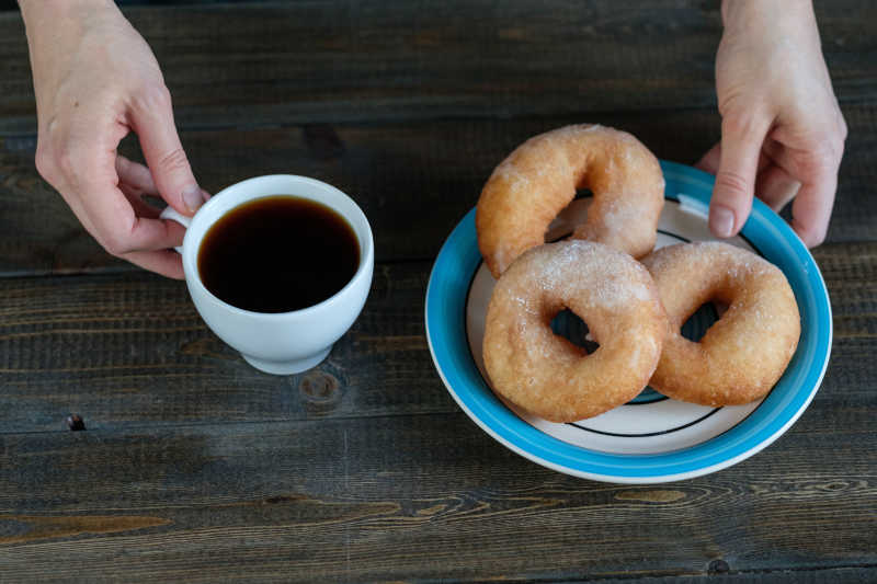 桌子上放着甜甜圈和一杯咖啡