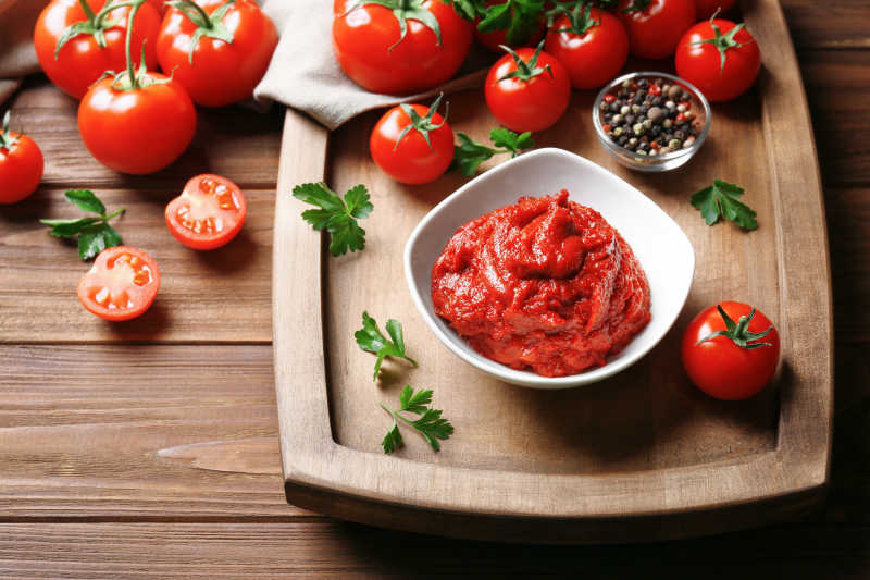 在木制桌子上碗中有美味的番茄酱