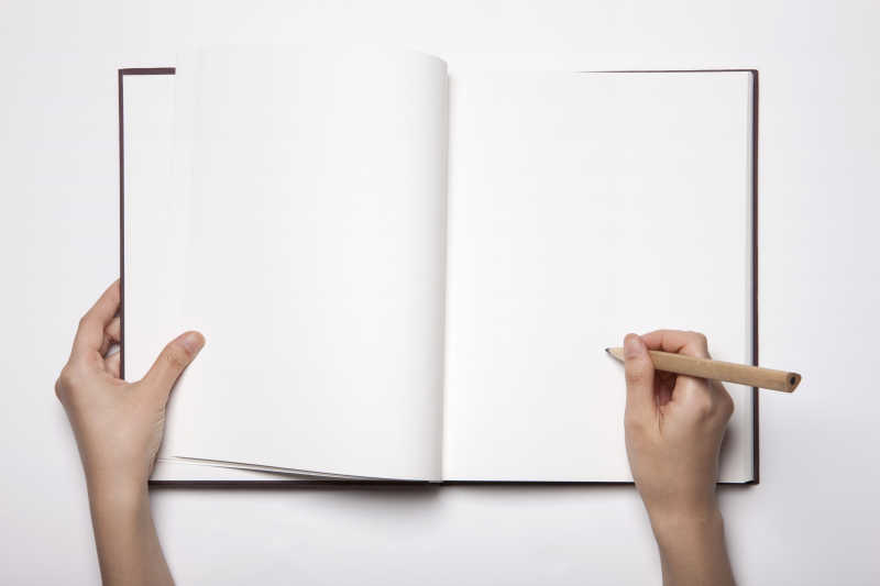 两只手拿着一个空的日记本