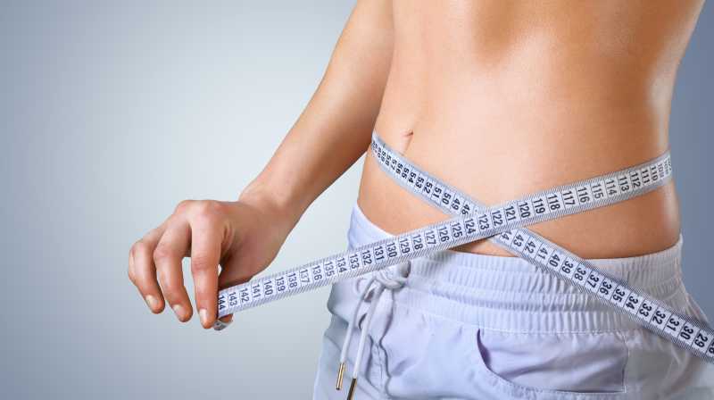 一个人在量自己的腰围