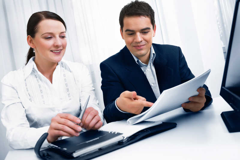 拿着报告正在讨论工作的同事