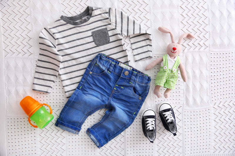 织物背景的婴儿服装套装加玩具