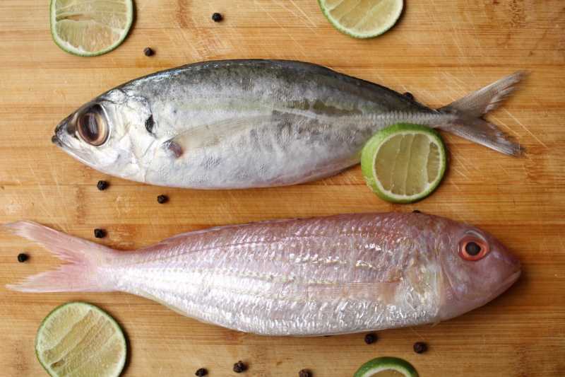 砧板上的新鲜海鱼和青柠檬片