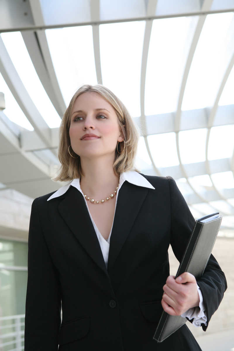 抱着笔记本面带微笑的美女