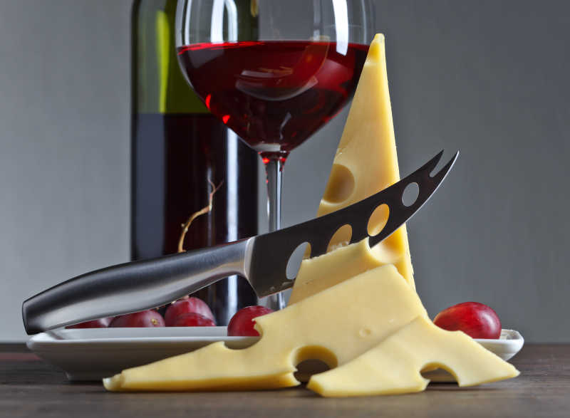 旧木桌上的奶酪和红酒