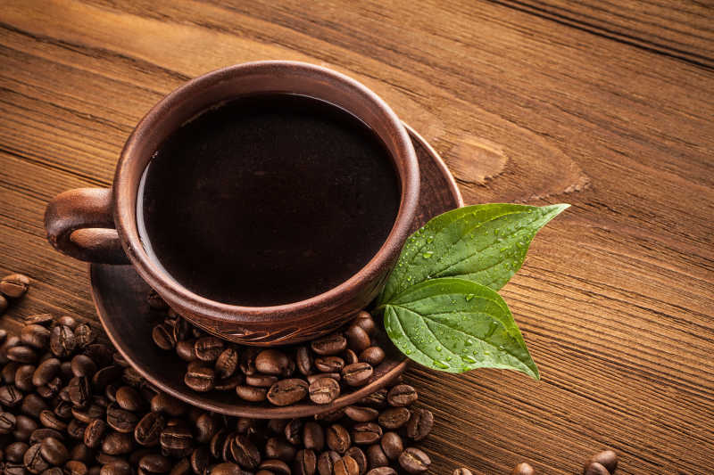 木桌上的咖啡豆与杯子里咖啡