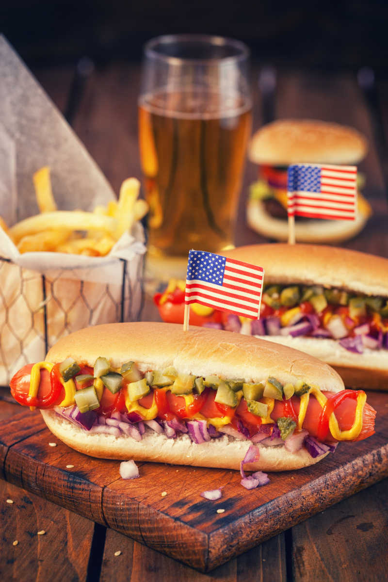 桌子上的热狗薯条汉堡还有酒