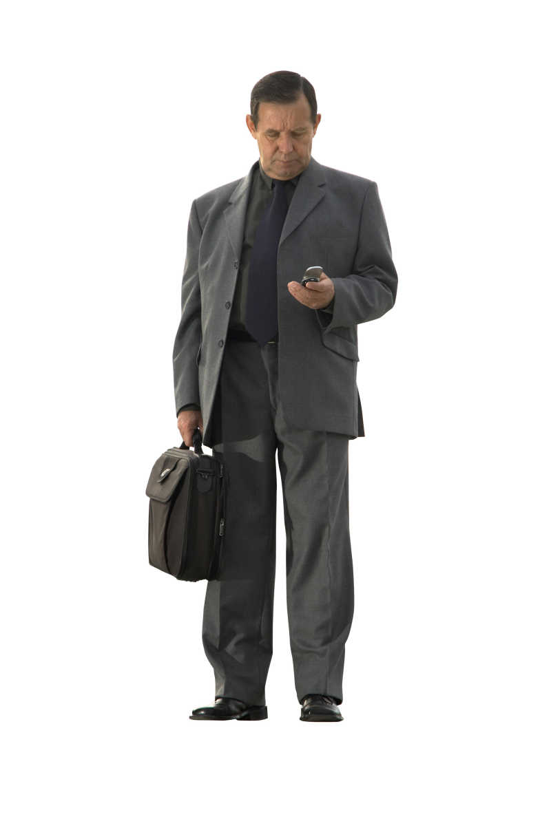 拿着手机低着头的商人