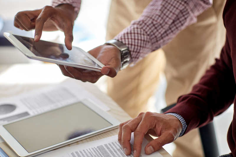 男人拿着平板电脑在议论