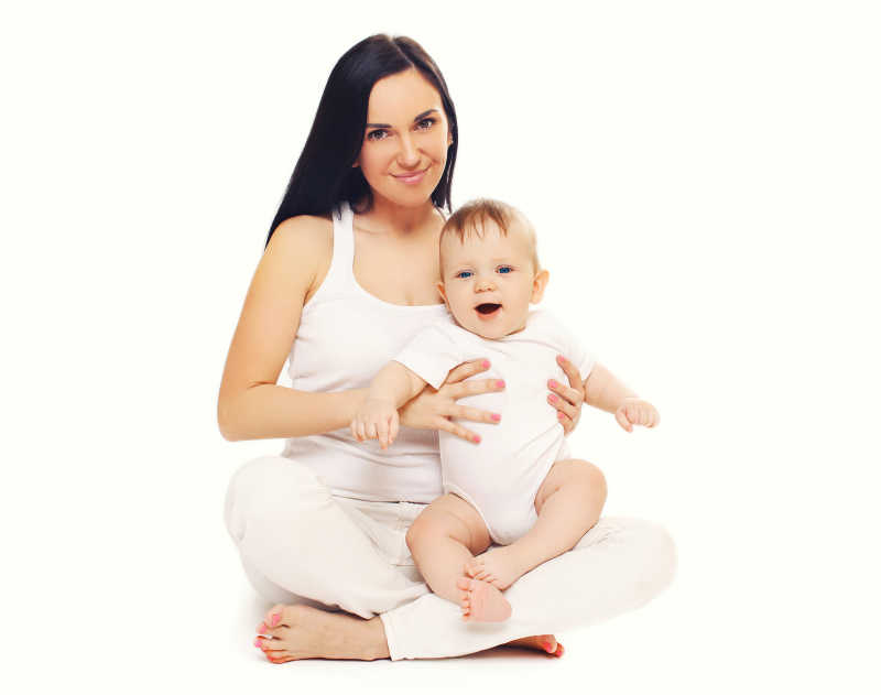 婴儿坐在年轻的母亲腿上