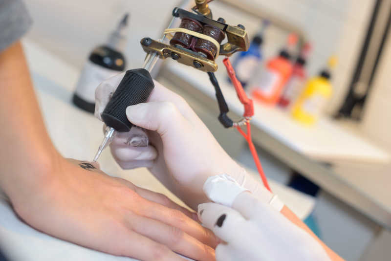 正在手背上纹身的艺术家