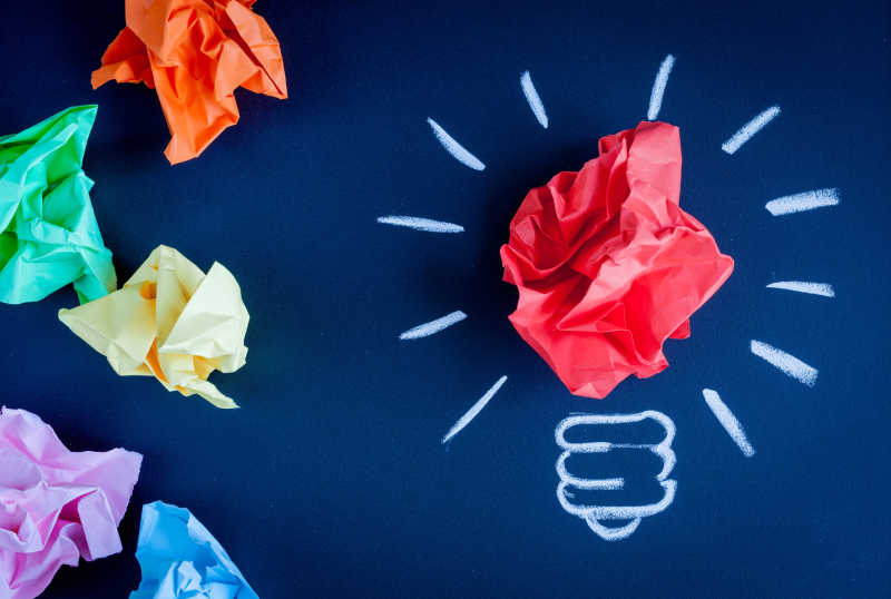 蓝色背景下的彩纸灯泡状的创意概念idea