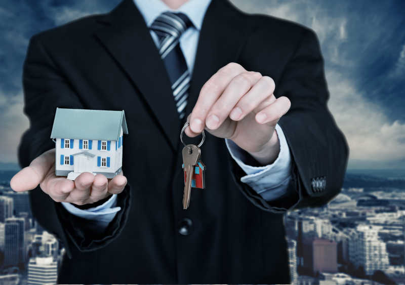 一只手拿钥匙一只手拿房屋模型
