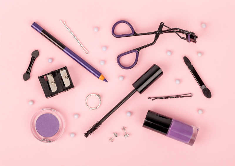 粉红色背景的专业套装化妆品及工具
