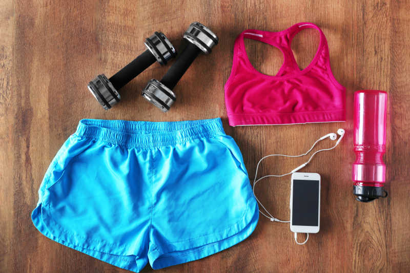 木质背景上的运动服装健身器材