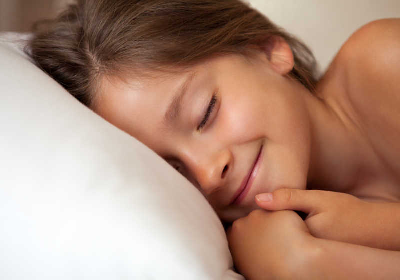 可爱的小女孩躺在床上睡觉