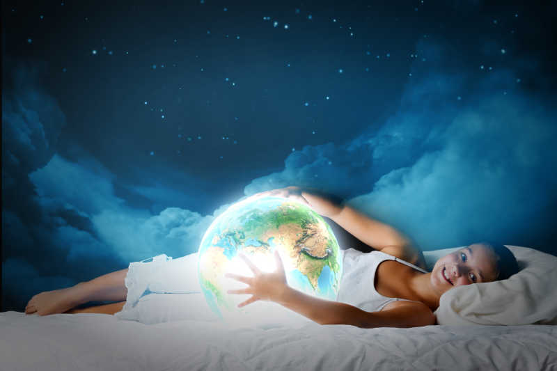 可爱的女孩睡在床上抱着地球的行星
