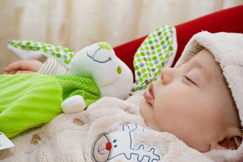 可爱的宝宝抱着毛绒兔子睡着了