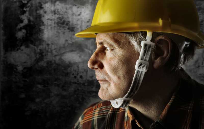 头戴黄色头盔的中年建筑工人