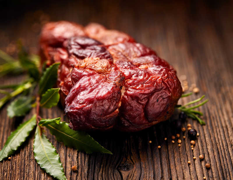 木质仿古桌上烟熏火腿和迷迭香