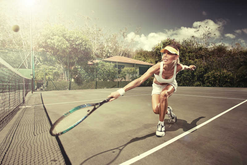 年轻美丽的女运动员打网球