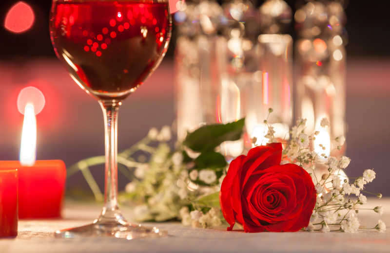 桌子上的玫瑰花蜡烛和红酒