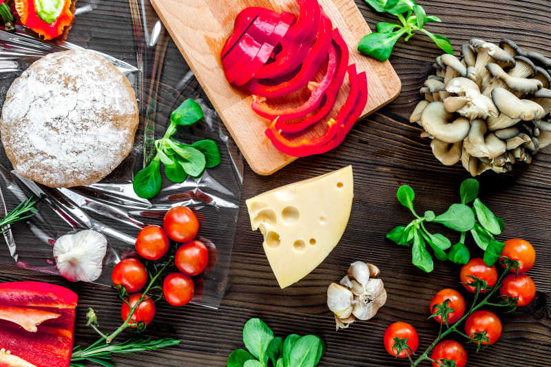 深褐色背景下什锦蔬菜和面团