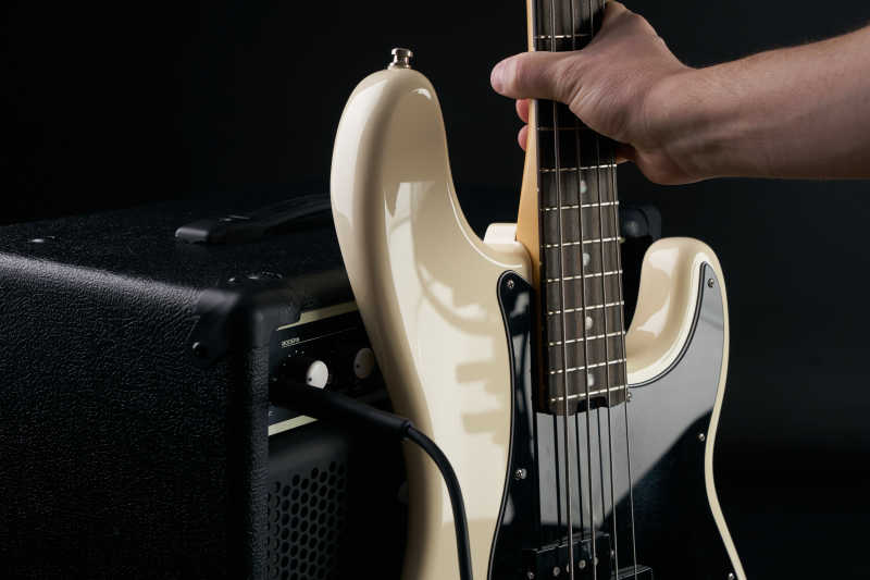 黑色背景上手手拿电吉他特写