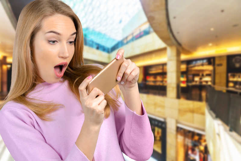 女人惊讶的看着手机