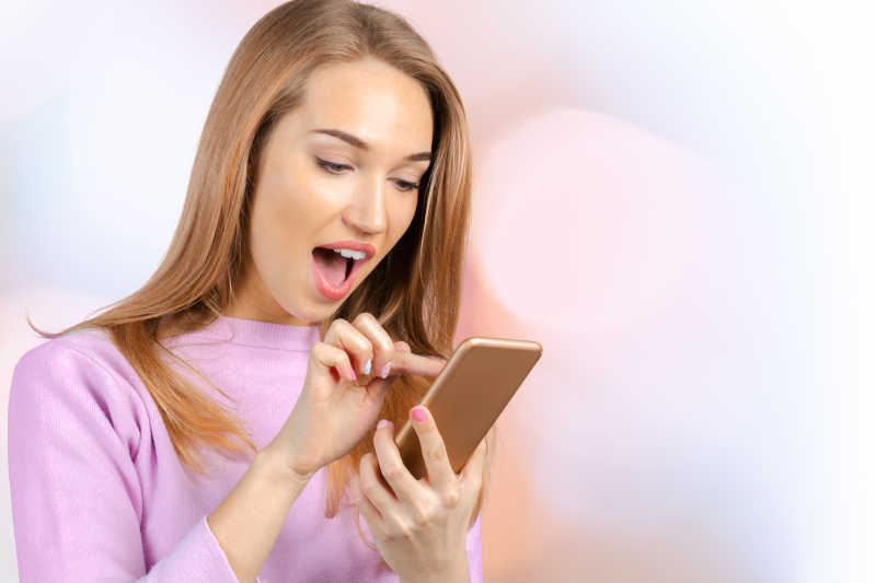 时尚美女看着手里拿着的手机